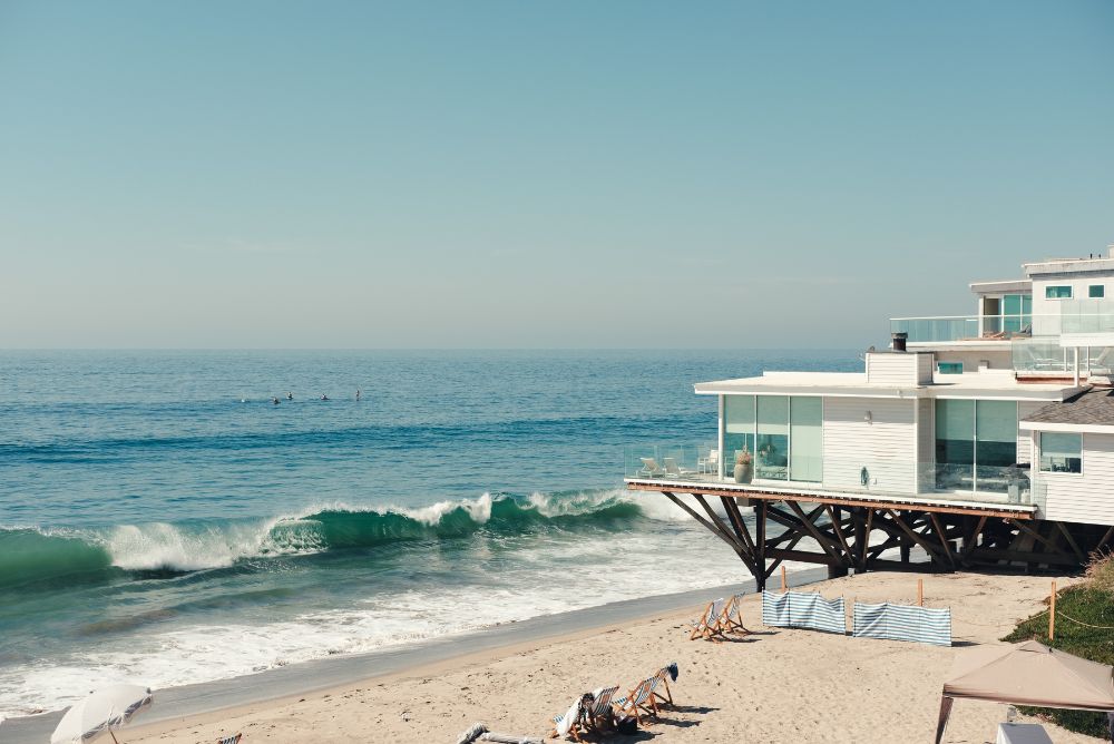 A white contemporary beach house over looks the pacific ocean on Malibu beach