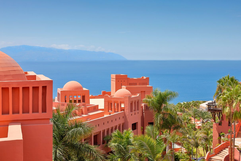 The terracotta-coloured rooftops of the buildings of the Ritz Carlton Abama in Tenerife, overlooking the Atlantic ocean on a bright sunny day.